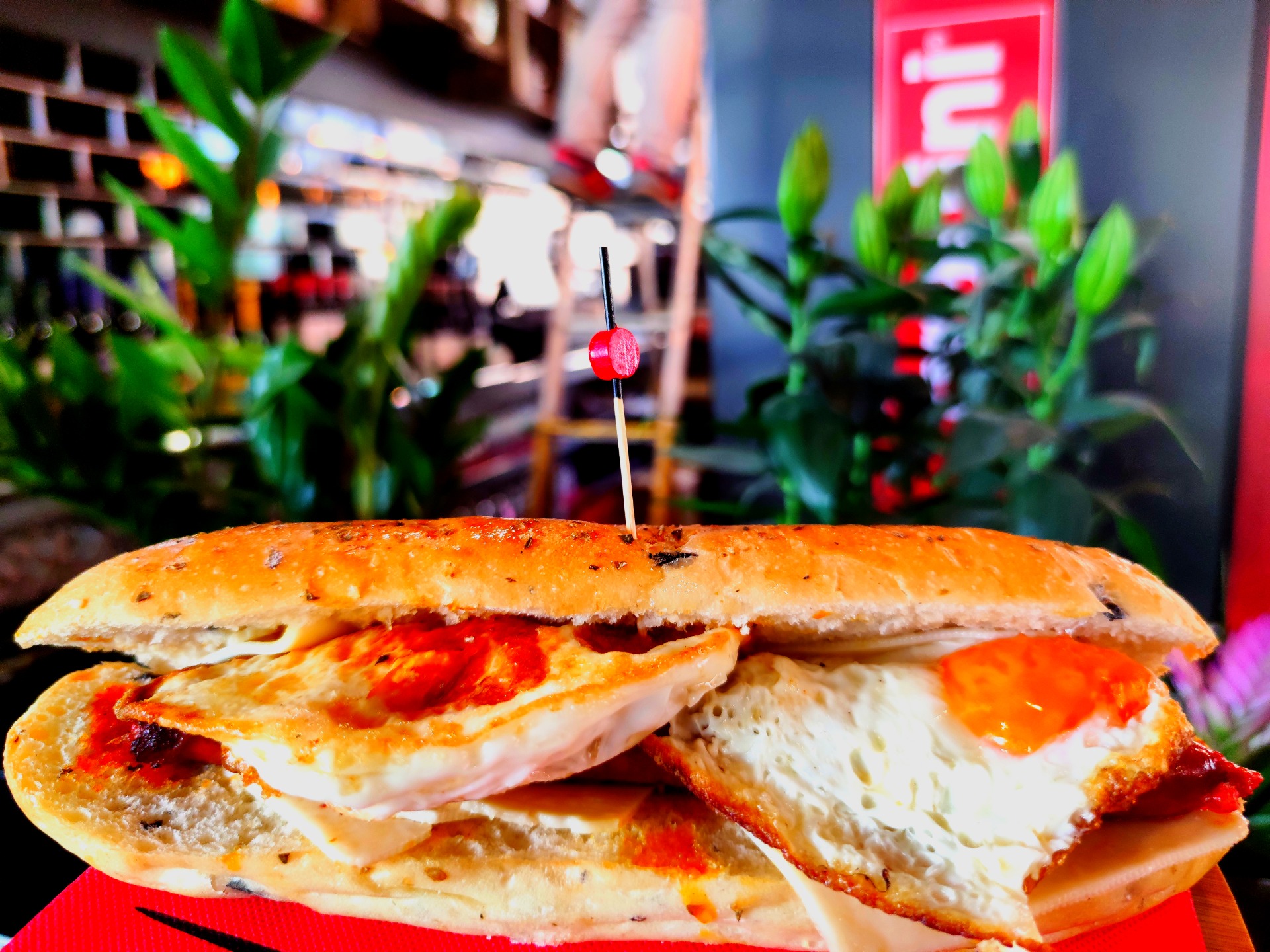 Huevos fritos, chistorra y queso fundido; sobre pan de frankfurt con aromas de oliva negra y orégano. ___ 7.5€
